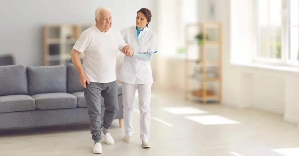 Health practitioner helping an older man walk safely outdoors
