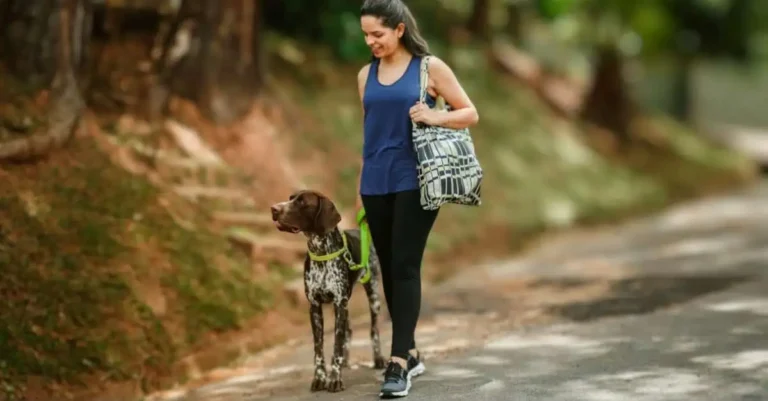 Lady walking her dog while enjoying the health benefits of walking every day