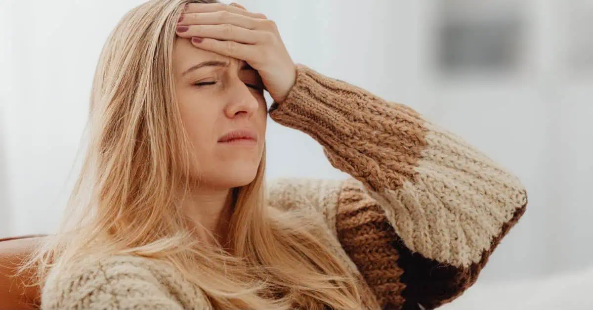 How to get rid of a headache as a woman holds her head in discomfort