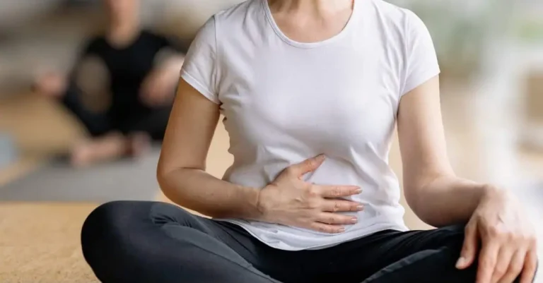 How long does menopause last? Woman sitting and holding her belly