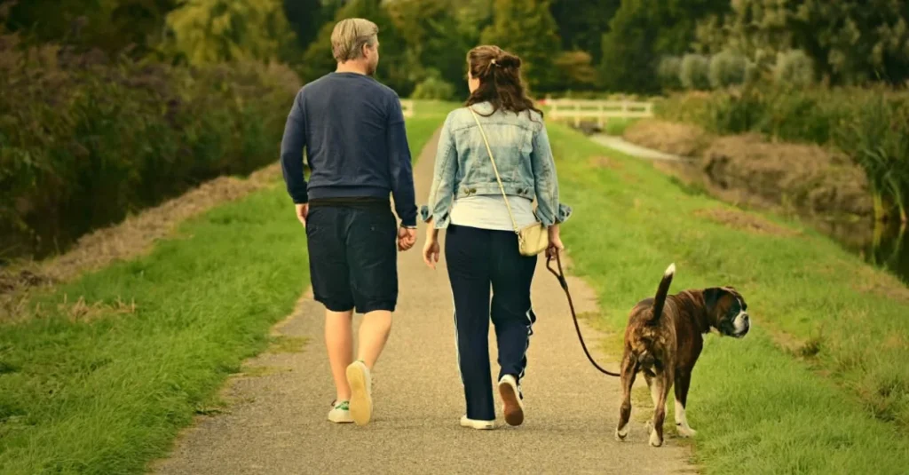 Couple walking outdoors with their dog
