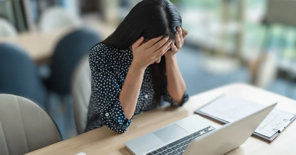 Woman sitting at her desk and struggling to concentrate on her work