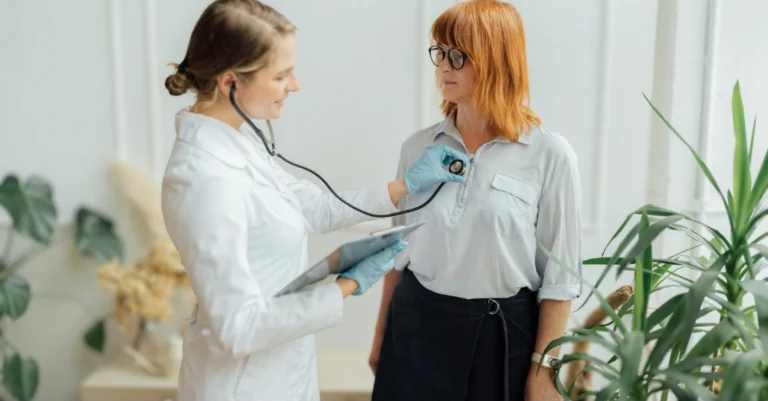 Women’s health checkup with a female doctor using a stethoscope